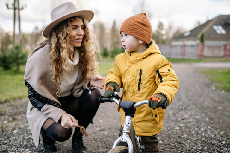 Adult teaching a child how to ride a bicycle